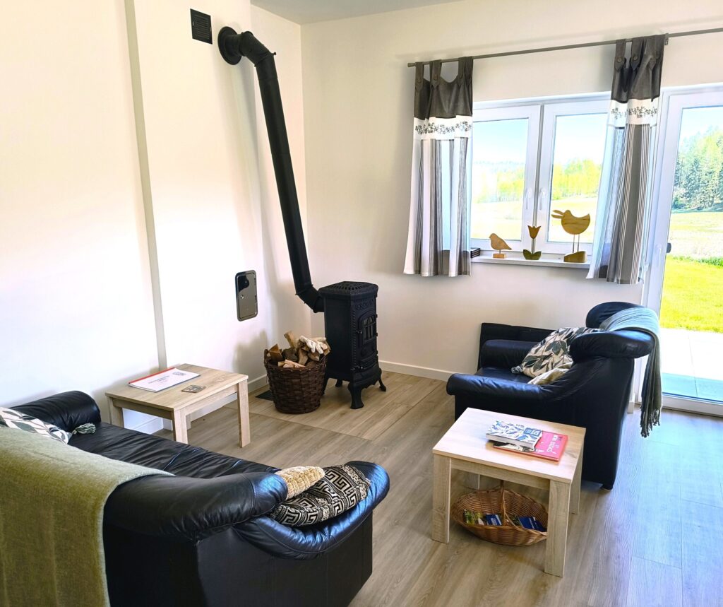 kącik wypoczynkowy z fotelami i kozą do ogrzewania