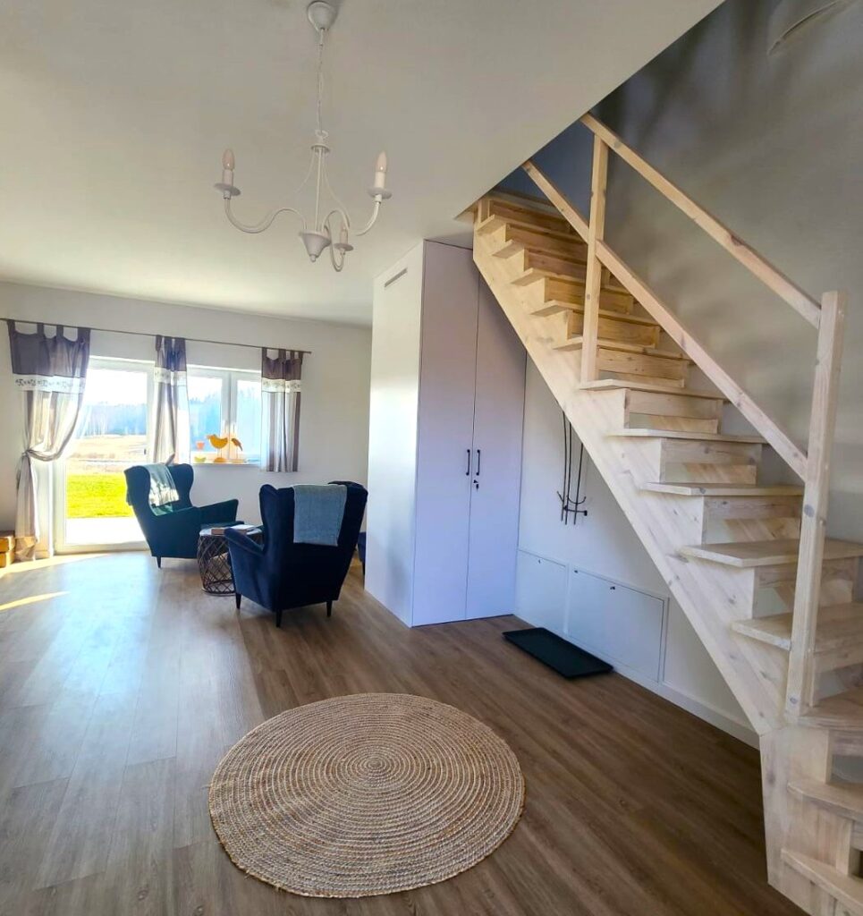 kącik wypoczynkowy i schody prowadzące na piętro domu